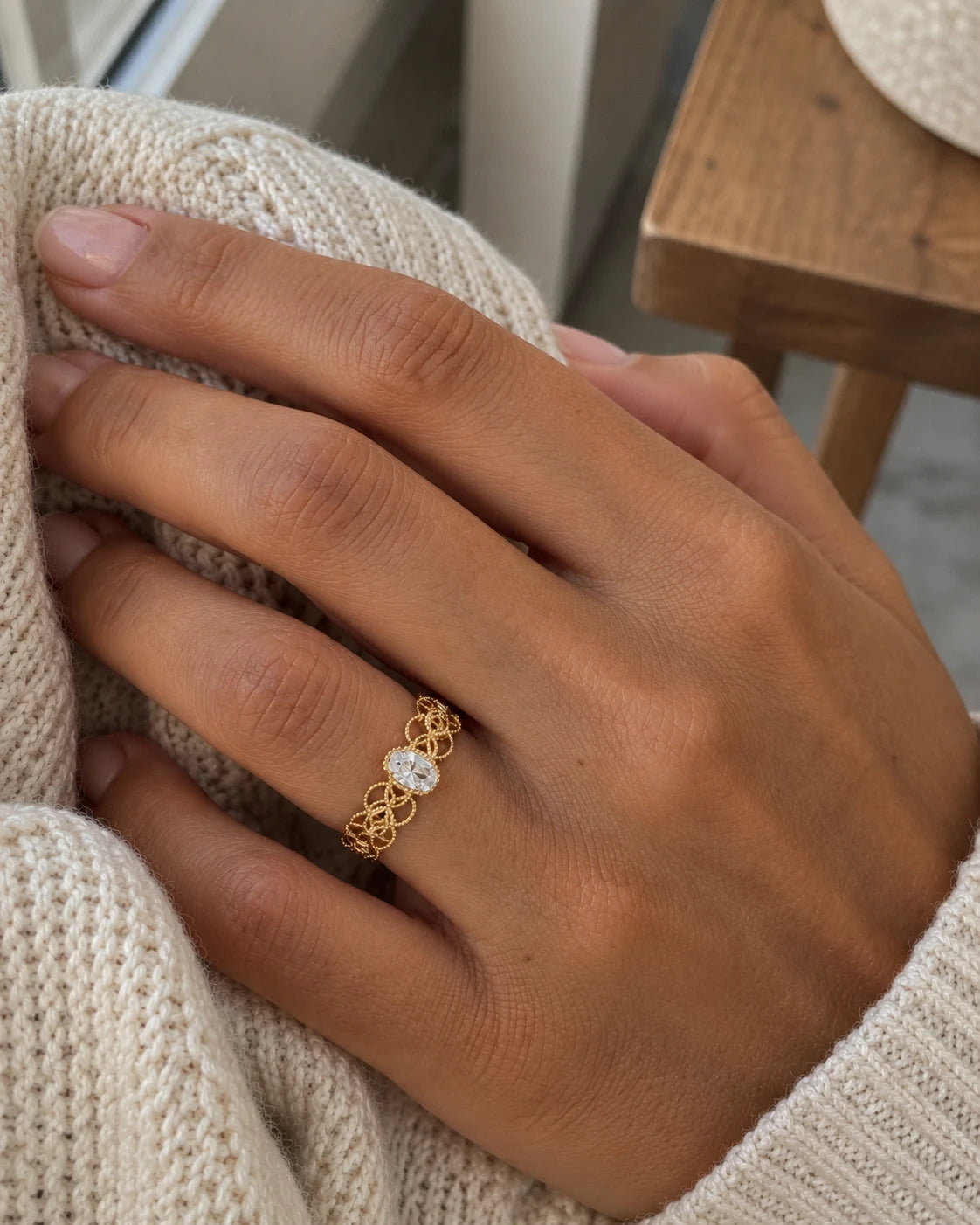 Bague CHIARA dorée ajourée portée avec un pull en maille crème – idée cadeau d'hiver