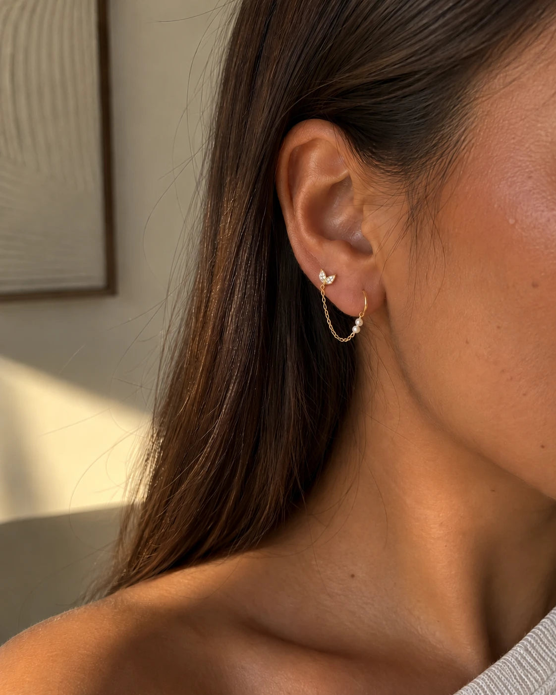 Piercing Vaea double trou porté : puce feuille en strass reliée par une chaîne à perles à une mini créole, acier inoxydable doré – bijou Adalima