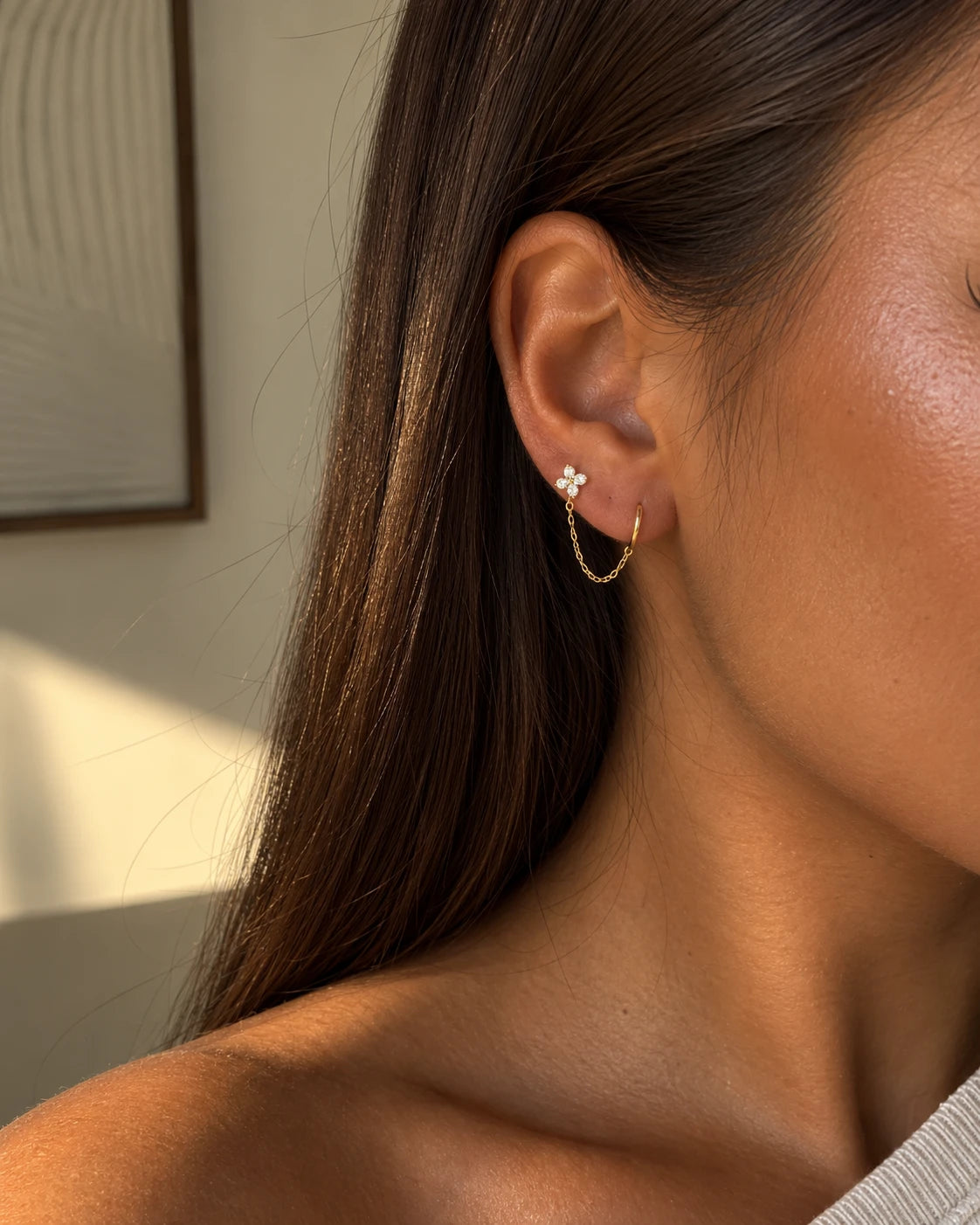 Piercing Leya double trou porté : puce fleur en zircons reliée par une fine chaîne à une mini créole, acier inoxydable doré – bijou Adalima