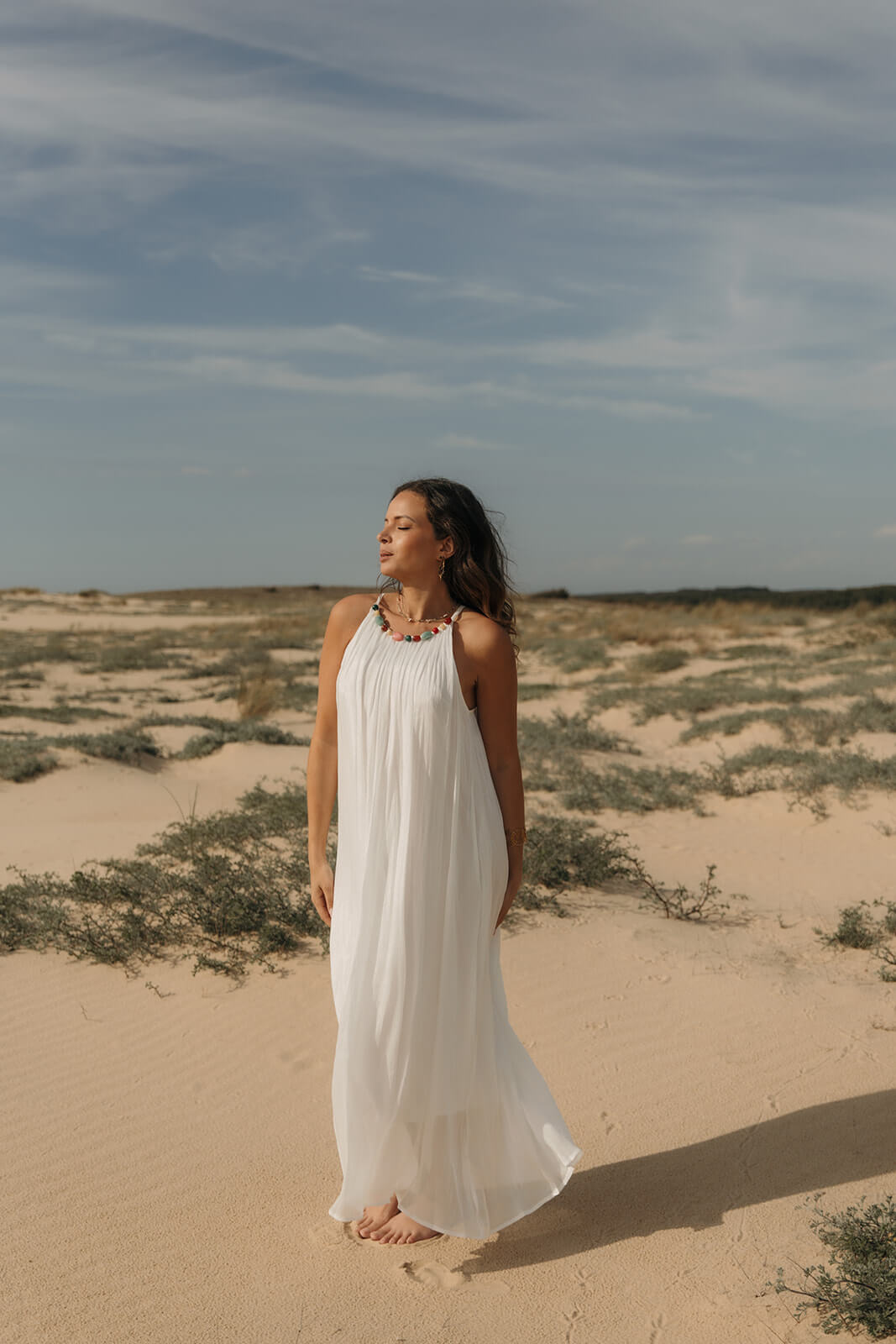 robe longue fluide blanche avec des perles colorées sur le col 